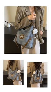 Blue canvas tote with M logo and plush cloud charm shown on a shoulder in detail