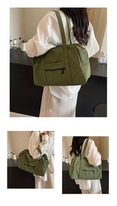 Sac de voyage en toile vert olive grande capacité porté à l'épaule en mode lifestyle