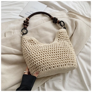 Detailed close-up of handmade cream woven tote bag with wooden bead and brown handle