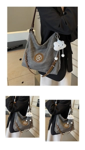 Detail of grey canvas tote bag with brown leather straps and cloud charm pendant