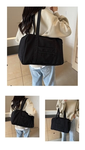 Détail d'un grand sac de voyage noir en tissu résistant avec une poche zippée pratique