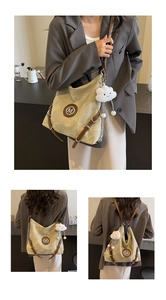 Detail of khaki canvas tote bag with brown leather trim and cute white cloud pendant
