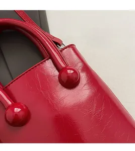 Vue macro d'un sac à main rouge en cuir verni avec coutures et détails de poignée premium