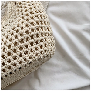 Close-up of high-quality woven texture on cream crochet tote bag with soft lighting