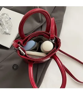 Vue de dessus de l'intérieur du mini sac rouge brillant montrant les compartiments