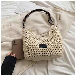 Detailed close-up of beige crochet tote bag featuring wooden bead handle and texture
