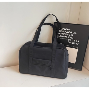 Détail d'un sac de voyage en nylon noir avec fermeture éclair en métal et poche latérale