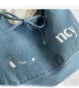 Detail of blue denim tote bag featuring white Rebawancy text and soft fabric texture