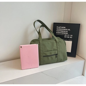 Détail du sac de voyage en toile vert militaire avec poche zippée sur marbre