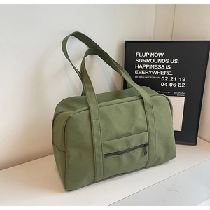 Détail du sac de voyage vert armée avec poignées larges et poche zippée