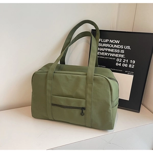 Gros plan du sac de voyage vert olive avec poche zippée et poignées de transport solides