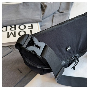Close-up of durable black nylon sling bag with heavy-duty plastic buckle and zipper