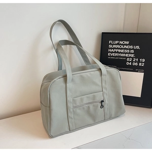 Gros plan du sac de voyage vert menthe avec poche zippée avant et longues bandoulières