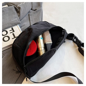 Top view of a black nylon crescent bag showing large capacity for cosmetics and accessories