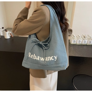 Detailed view of the light blue denim tote bag with Rebawancy print and bow shoulder strap