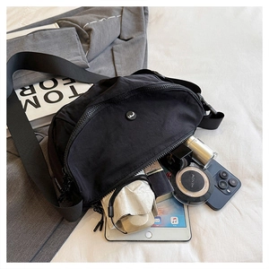 Detail of black nylon saddle bag showing large capacity for tablet and cosmetics