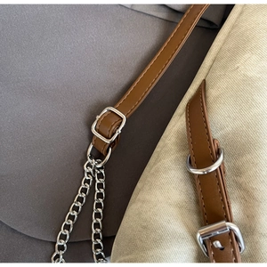 Detail of brown leather strap with silver chain and metal buckle for a large tote bag