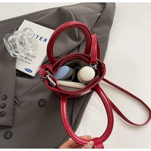Vue intérieure du mini sac seau rouge brillant montrant l'espace pour les cosmétiques