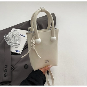 Sac seau beige chic avec détails de perles blanches sur fond de blazer gris élégant