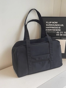 Grand sac de voyage noir à double poignée et poche zippée sur marbre luxueux