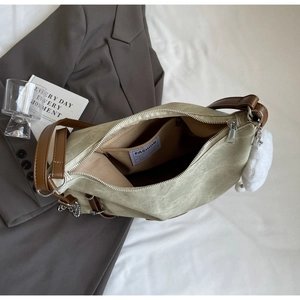 Detail view of light green tote bag with heart charm and interior fashion label pocket