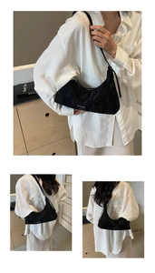 Close-up of black pleated hobo bag with logo and views of the minimalist crossbody style