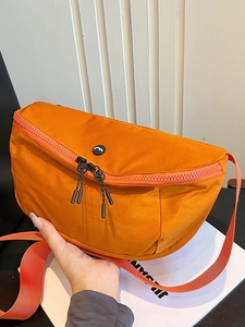 Orange nylon crescent crossbody bag with double zippers and adjustable strap for women