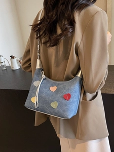 Navy denim crescent shoulder bag with colorful heart patches and silver metallic strap