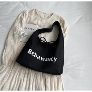 Detail of black denim tote bag with Rebawancy script logo and bow tie ribbon