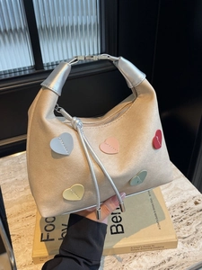 Chic beige hobo bag with colorful leather heart patches and silver metal handle