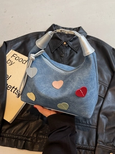 Blue denim handbag with colorful stitched heart patches and silver metal handles