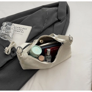 Interior view of white patent leather underarm bag showing spacious storage for essentials