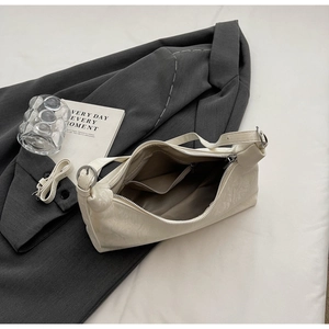 Detail of cream leather shoulder bag interior with fabric lining and zip pocket