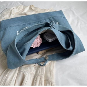 Top view of large capacity blue denim tote bag with magnetic closure and inner storage space
