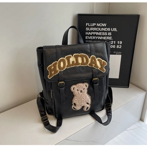 Detail of black PU leather backpack with plush bear motif and Holiday letter embroidery
