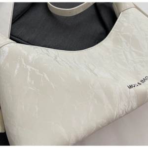Detailed view of cream hobo bag featuring crinkled leather texture and MKXQ branding