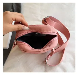 Detail view of pink crossbody canvas bag with spacious interior and inner zipper pocket