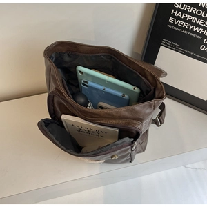 Internal view of vintage brown leather backpack showing spacious compartments for gadgets