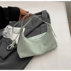 Detailed macro view of mint green glossy wrinkled texture on the semi-circular bag