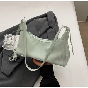 Close-up of light green underarm bag with marble texture and silver zipper detail