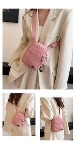 Pink canvas crossbody bag featuring dual zipper compartments and adjustable strap
