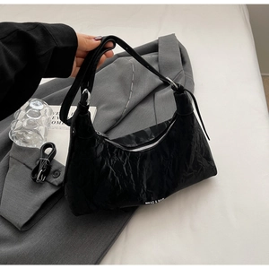 Detail showing the pleated black hobo bag with a silver zipper and crescent shape