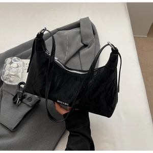 Close-up of black pleated texture shoulder bag with silver metal ring and MKXQ logo