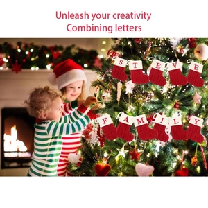 Red knit Christmas stockings with white alphabet letters hanging by a cozy fireplace