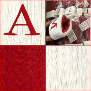 Macro details of knitted Christmas stockings with alphabet embroidery and cable textures
