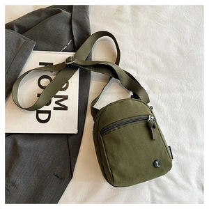 Detail of army green canvas crossbody bag with adjustable strap and zip pocket