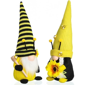Dettaglio di due gnomi della festa delle api con girasole e bastoncino di miele decorati