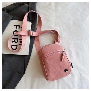 Pink sporty mini crossbody bag with logo detail on a stylish textured background