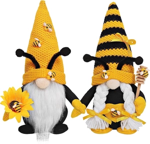 Detailed view of male and female bee gnomes with sunflower and honey dipper tools