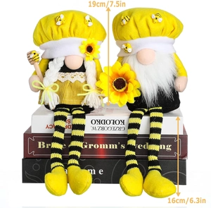 Detail of bee gnomes with sunflowers and honey dippers on stacked books decor